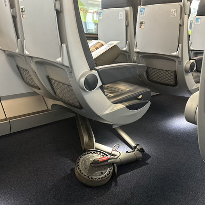 E-Roller Mitnahme in der Westbahn unterhalb des Sitzplatzes